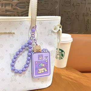Cute purple bear sliding puzzle keychain with purple beaded wristlet attached to a white bag