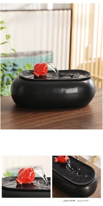 Detail of creative ceramic fountain featuring a red koi fish spout on black matte basin