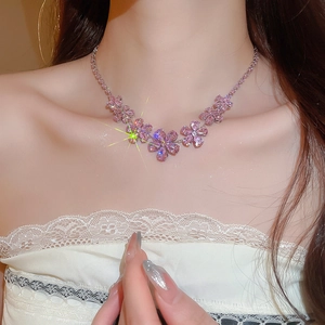 Detail of flower necklace with pink crystal petals on a sparkling silver-tone chain