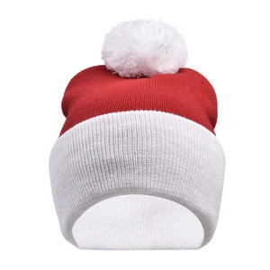 Detailed view of red and white knitted Christmas beanie with a large fluffy white pompom