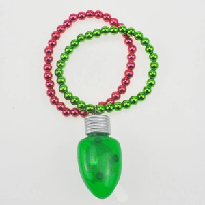 Macro shot of festive red and green beaded necklace with green LED bulb pendant ornament