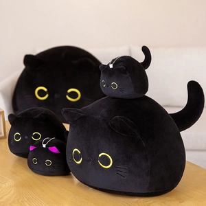 Zwarte kat pluche kussens in verschillende maten met gele ogen op een houten tafel