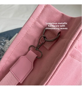 Dettaglio borsa tote in tela rosa con ganci in metallo grigio e finiture in pelle