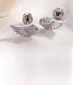 Macro detail of silver angel wing cartilage studs with cubic zirconia and steel backing