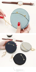 Detail view of mini cat ear coin purse with golden keychain and zipper closure
