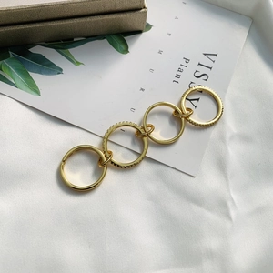 Detail of linked golden rings with micro-pave crystal inlay on white silk fabric