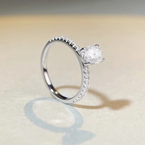Macro shot of large round brilliant moissanite ring with pavé-set side stones on silver band