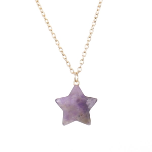 Detailed macro view of a 2.5cm purple crystal star pendant on a gold chain necklace