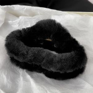 Detail of black plush hair claw clip featuring soft faux fur and durable gold metal spring