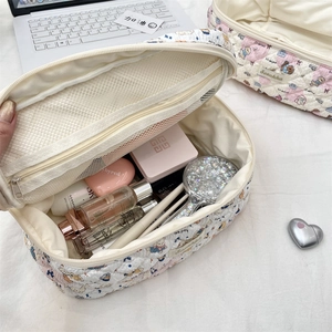 Detail of open quilted toiletry bag with cartoon animal prints and inner mesh pocket