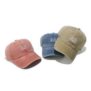 Detailed embroidery of cute dog on three washed canvas baseball caps in varied colors