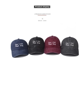 Detail display of vintage washed cotton baseball caps in four colors with dog embroidery