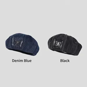 Denim beret hats in blue and black colors with butterfly patch and frayed edges