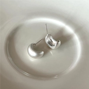 Detailed close-up of silver 925 U-shape hoop earrings with a matte brushed finish