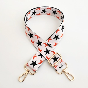 Close-up of thick woven bag strap with colorful stars and gold adjustable buckles