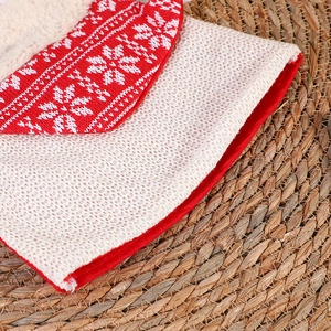 Nahaufnahme eines rot-weiß gestrickten Weihnachtssockens mit Schneeflockenmuster