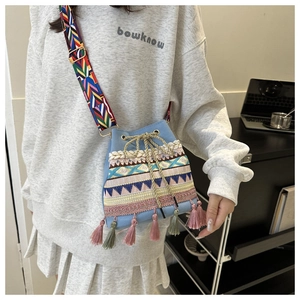 Close-up of bohemian bucket bag with colorful ethnic embroidery and long tassels