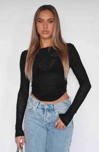 Detail of sheer black mesh long sleeve crop top paired with casual light blue jeans