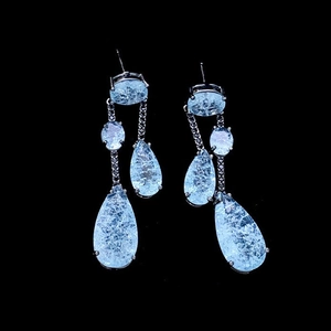 Detailed view of light blue teardrop earrings with ice-crack pattern in silver setting