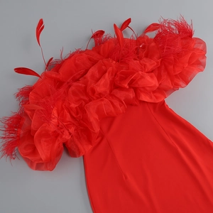 Close-up of red feather trim and layered organza ruffles on a strapless party dress