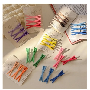 Close-up of matte candy-colored X-shaped hair clips in various vibrant pastel shades