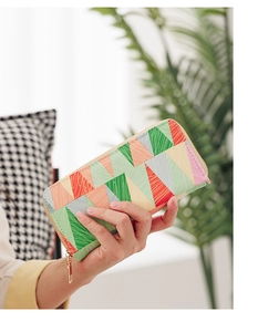 Detail of colorful geometric triangle pattern on a long clutch wallet with gold zipper