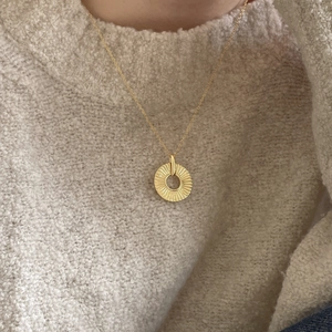 Minimalist 925 sterling silver golden sunburst round pendant necklace worn on a sweater