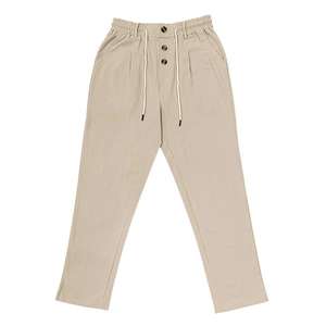 Close-up of drawstring waist and decorative buttons on beige linen blend men's pants