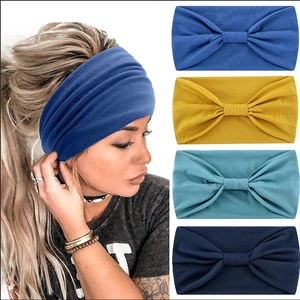 Elastic wide yoga headband with knot detail shown in four colors and model wear