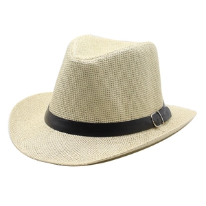 Close-up of woven straw cowboy hat featuring a black leather band and silver metal buckle