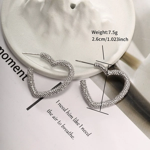 Detailed view of silver heart hoop earrings with matte texture, 2.6cm size and 7.5g weight