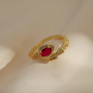 Macro detail of 18K gold plated snake ring featuring a red gemstone and clear zircon stones