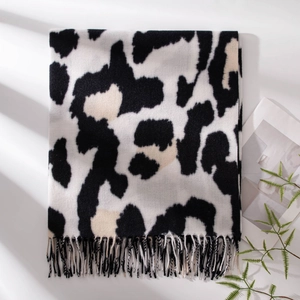 Soft faux cashmere scarf featuring black and beige leopard print with tassel edges