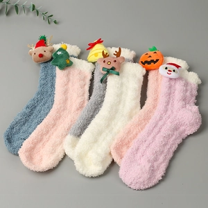 Detail von fünf Korallenvlies-Socken mit weihnachtlichen 3D-Cartoon-Puppenmotiven