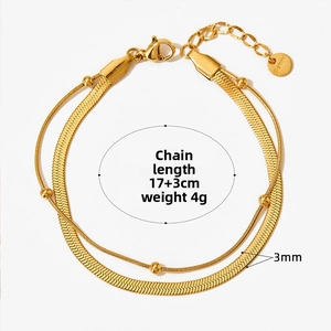Detail of gold snake chain bracelet with round beads and lobster clasp closure