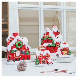 Close-up of a cozy LED glowing ceramic red snow house ornament set for Xmas decor
