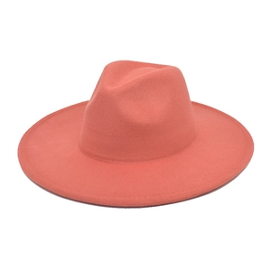 Macro detail of coral pink wide brim wool fedora hat with classic indented crown design