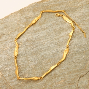 Minimalist 14K gold filled irregular link necklace on a textured stone surface