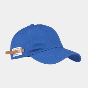 Detail of royal blue cotton baseball cap with white label and brown leather strap buckle