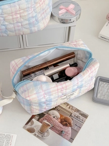 Detail of blue and pink checkered quilted makeup bag with soft cotton heart stitching