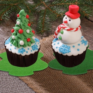 Detail of felt Christmas tree and snowman drink coasters on a rustic wooden tabletop