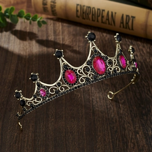 Detailed shot of vintage gold crown with pink crystals on dark wooden background