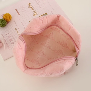Detailed view of the soft pink plush quilted makeup bag showing smooth zipper and lining