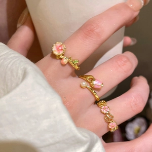 Detail of 18k gold plated floral rings with pink enamel tulips and pearl accents