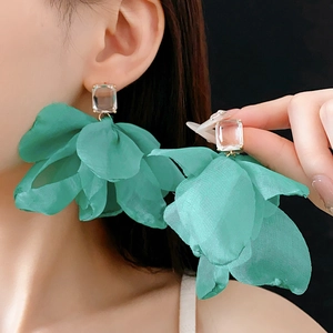 Makroansicht grüner Tüll-Blumenohrringe mit quadratischem Kristallstecker am Modell