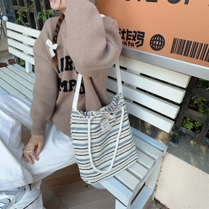 Close-up of striped canvas tote bag with braided rope strap and large capacity design