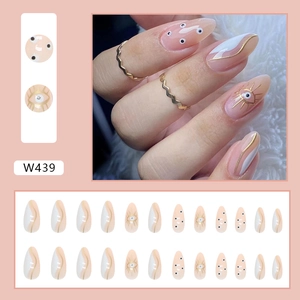 Detail of 24pcs nude almond press-on nails with white patterns and gold line accents