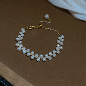 Détail du bracelet tressé à double rangée de perles avec chaîne dorée réglable