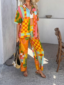 Detail shot of bohemian resort set featuring colorful geometric and tropical print pants