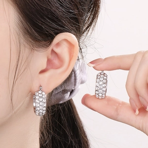 Detail of silver hoop earrings featuring three rows of sparkling inlaid rhinestones